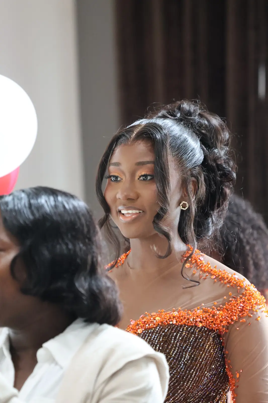 Perla smiling among guests at the engagement celebration.